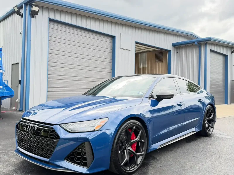 Sleek blue Audi sedan parked outside shop featuring window tinting Navasota TX