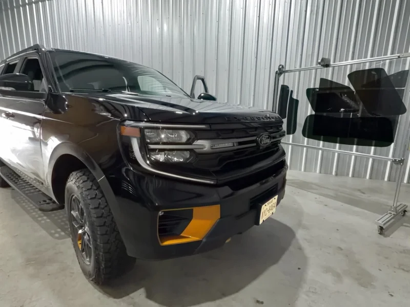 Black Ford pickup truck inside shop with dark window tinting Navasota TX
