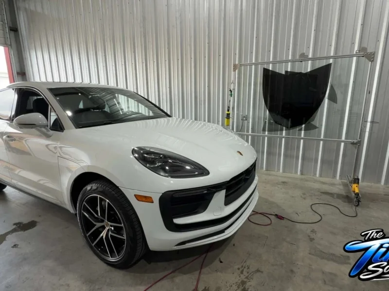 White Porsche SUV inside shop bay after receiving window tinting Navasota TX