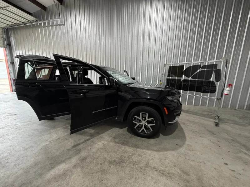 Black SUV parked inside garage showing completed window tinting College Station area